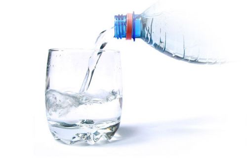Воду из бутылки наливают в стакан